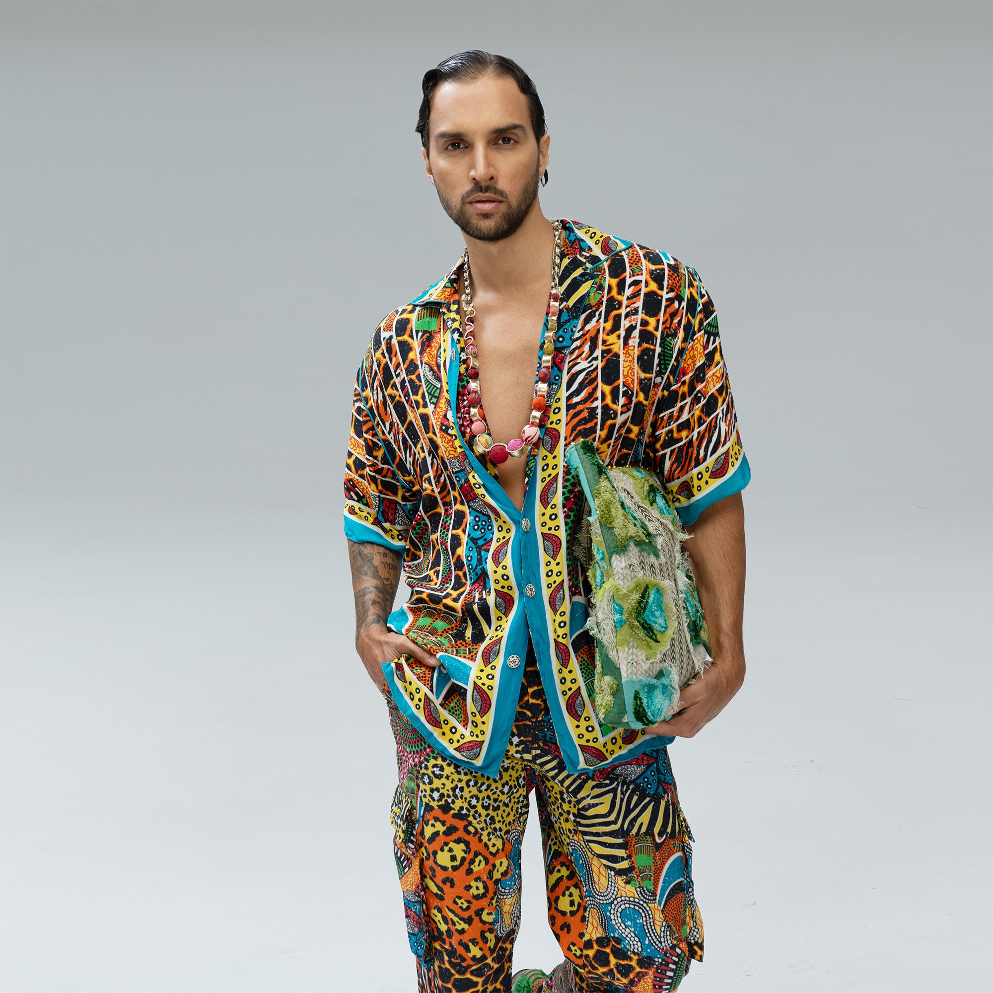 High-fashion editorial photograph of a male model in masculine pose, wearing vibrant, multi-color patterned ensembles from the Paul Ropp bohemian luxury collection against a minimal studio background.

Available in-store, Bali, Indonesia